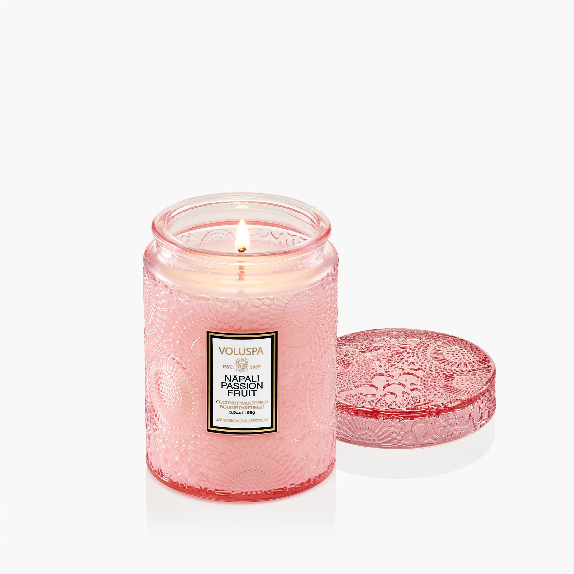 Pink candle with a visible brand label on a white background