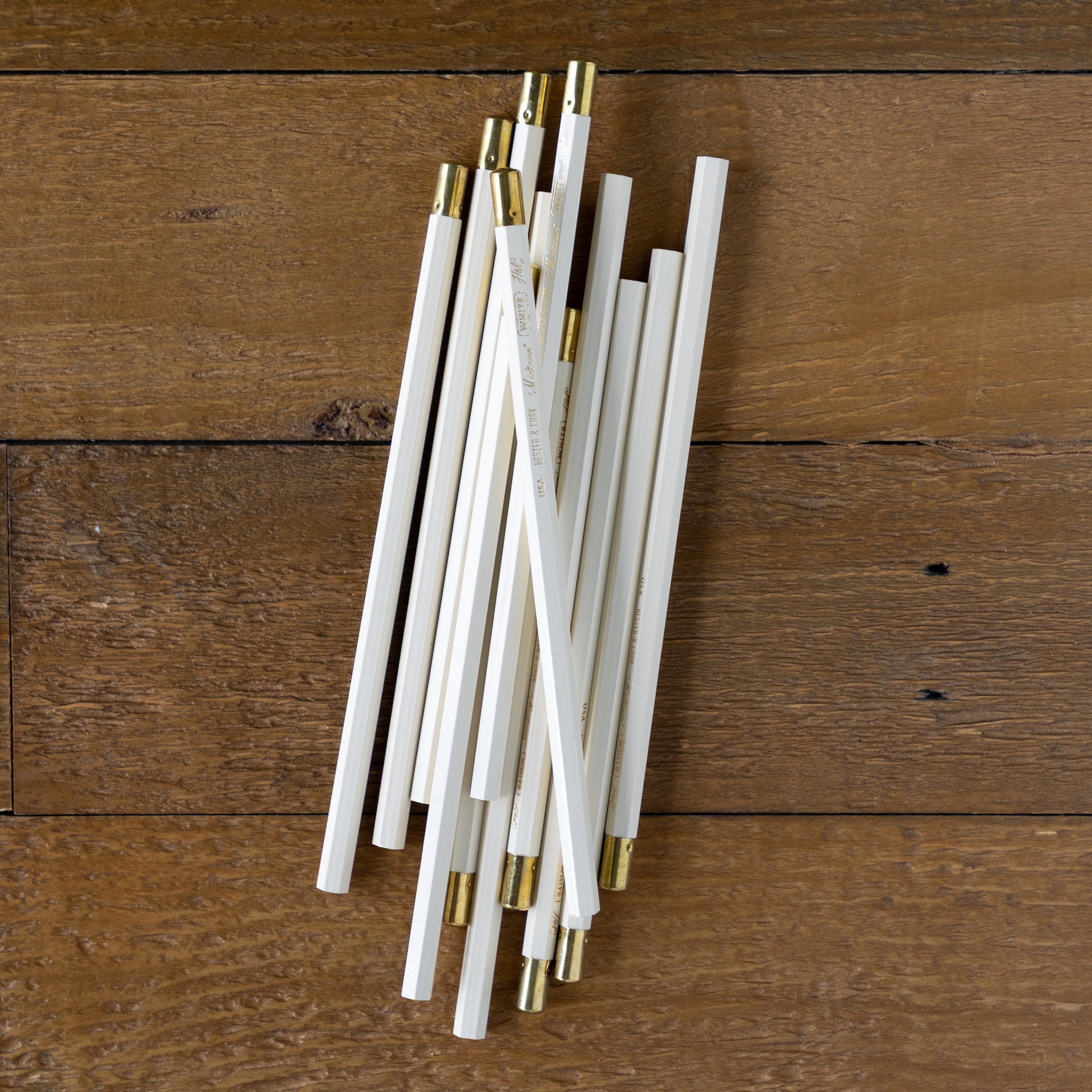 Group of Midtown Hex pencils grouped together on a wood background. 