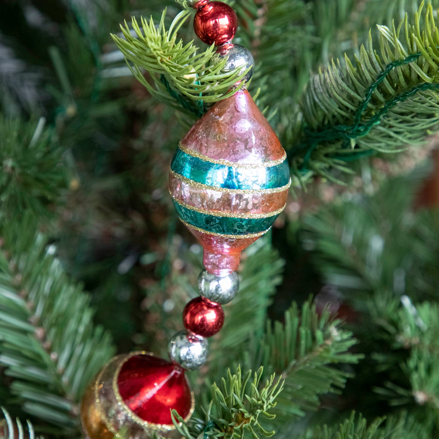 A close up of the Retro Tinsel and Glass Finial Garland showing its 50s style bulb.