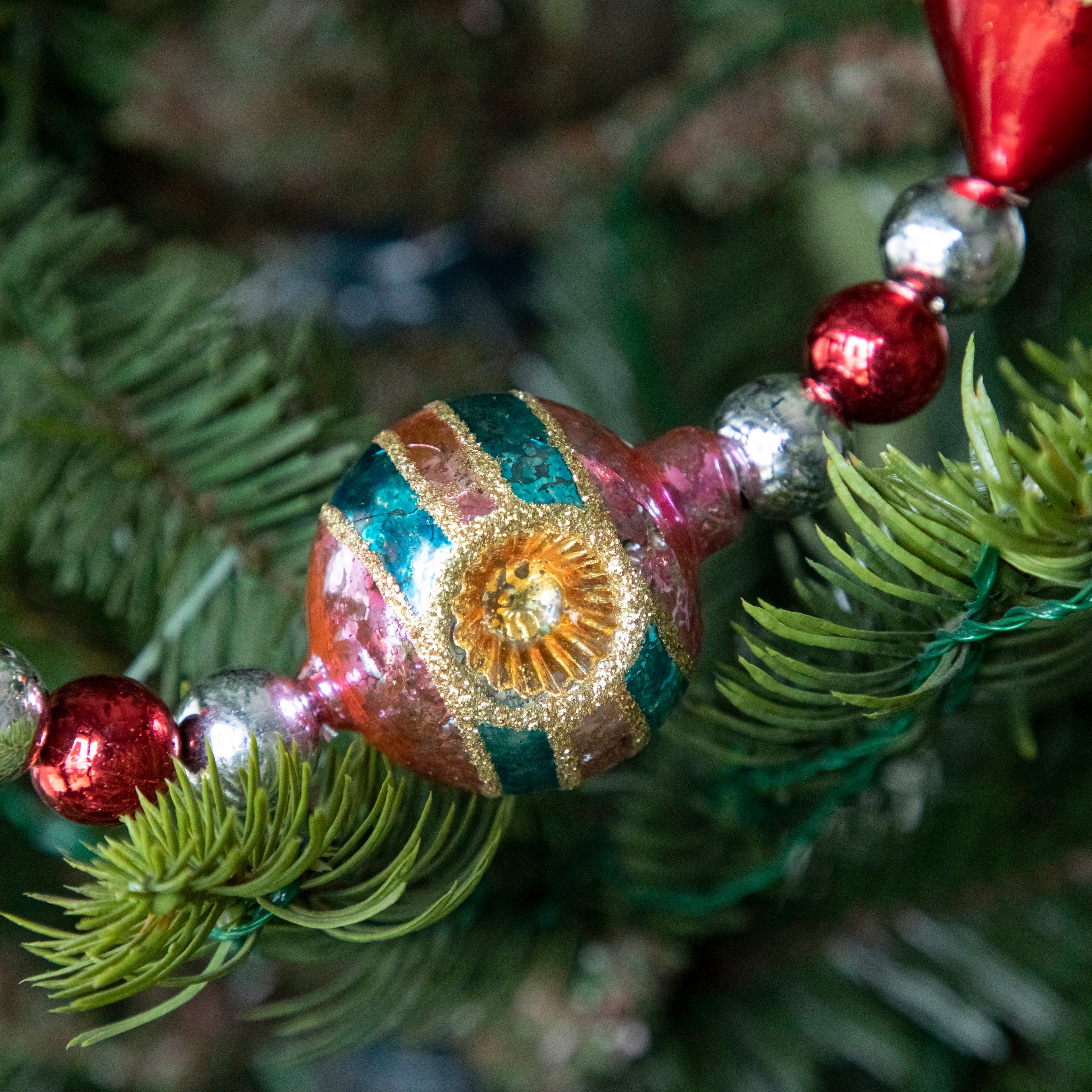 A close up of the Retro Tinsel and Glass Finial Garland showing its 50s style bulb.