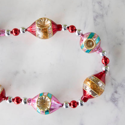 The  Retro Tinsel and Glass Finial Garland on a marble table.