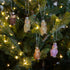 Decorative owl ornaments on a Christmas tree with lights.
