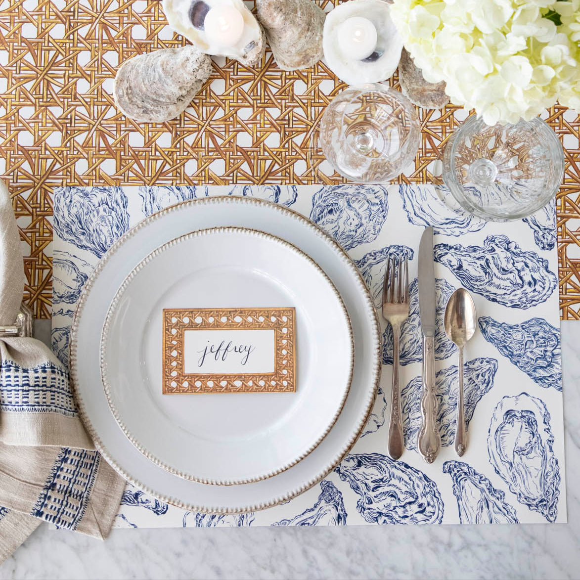 Rattan Weave Place Card with &quot;Jeffrey&quot; written on it, on a nautical themed table setting.