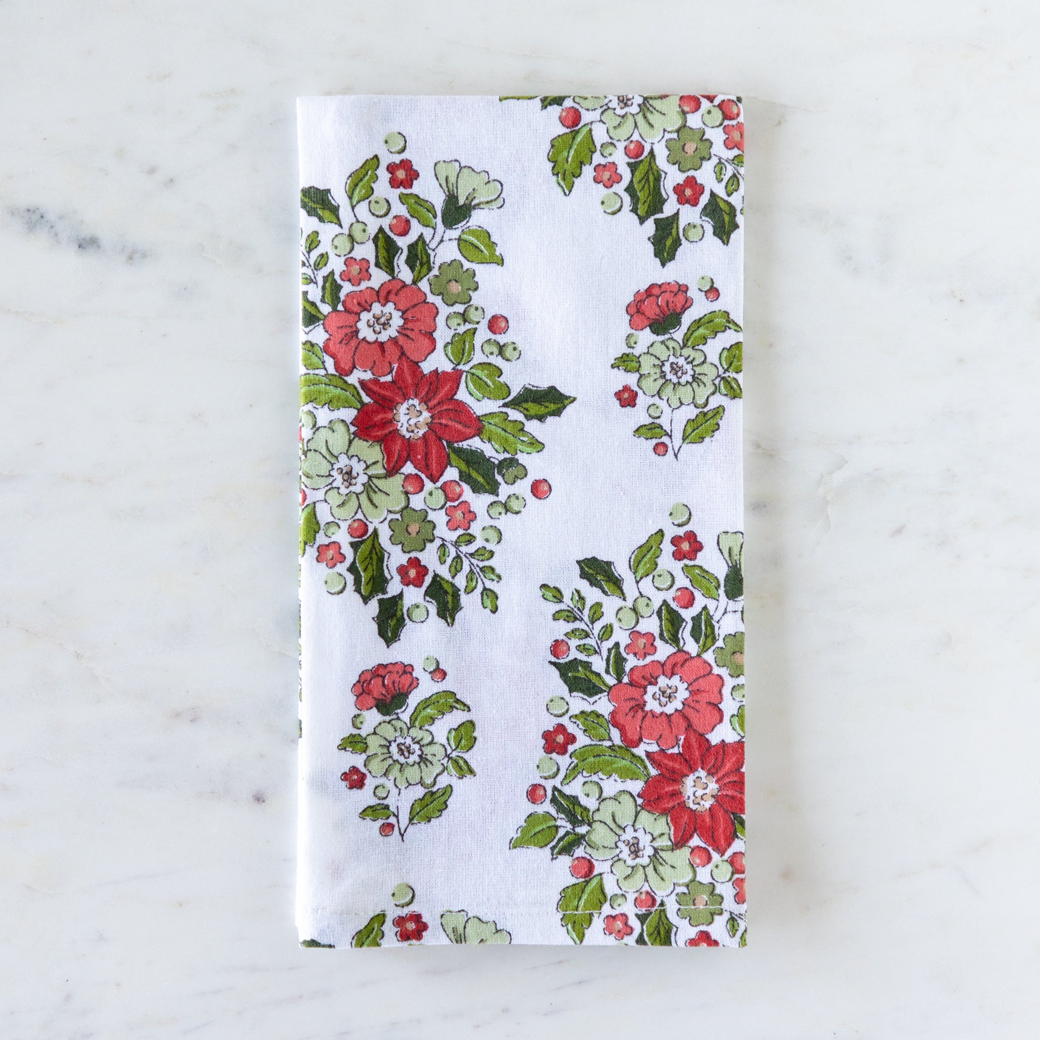 Holly &amp; Berry Ivory Napkin folded on a marble table.