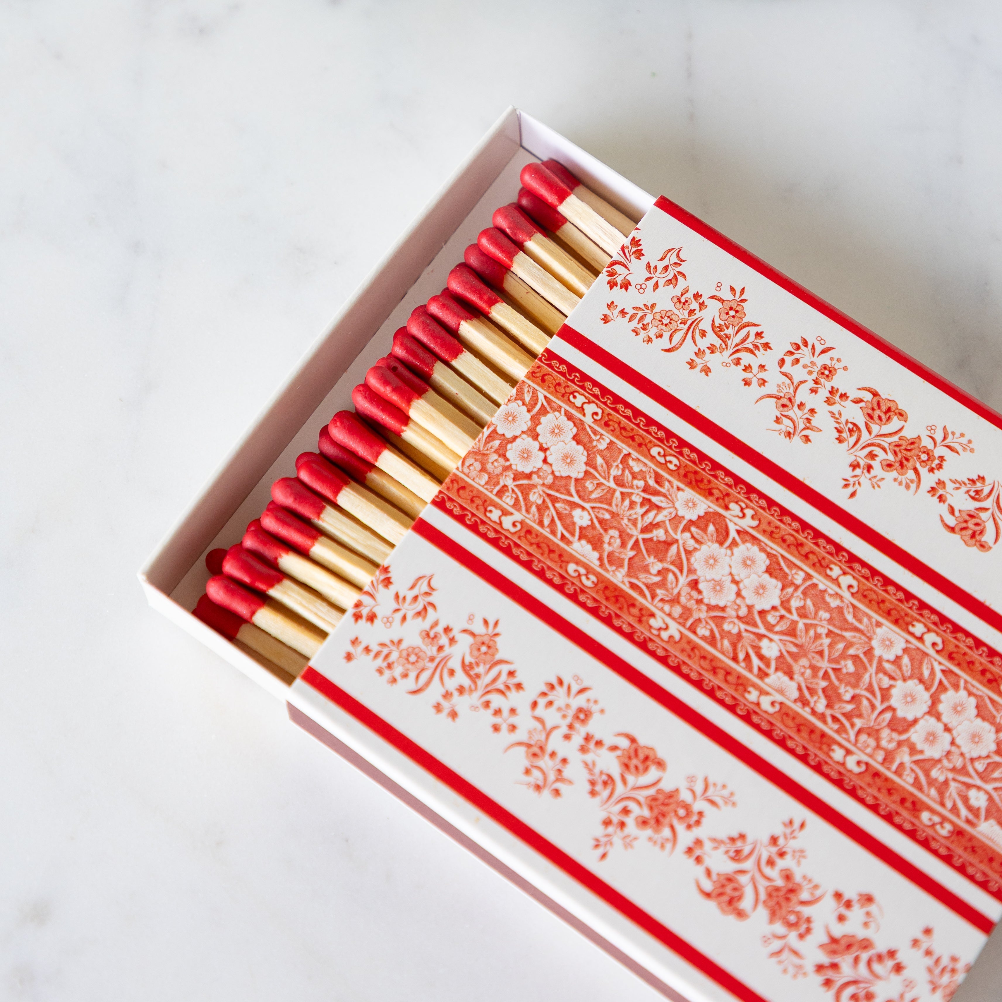 A close up the Red Burleigh Stripe matchbox with the box slightly open showing the tips of the matches.