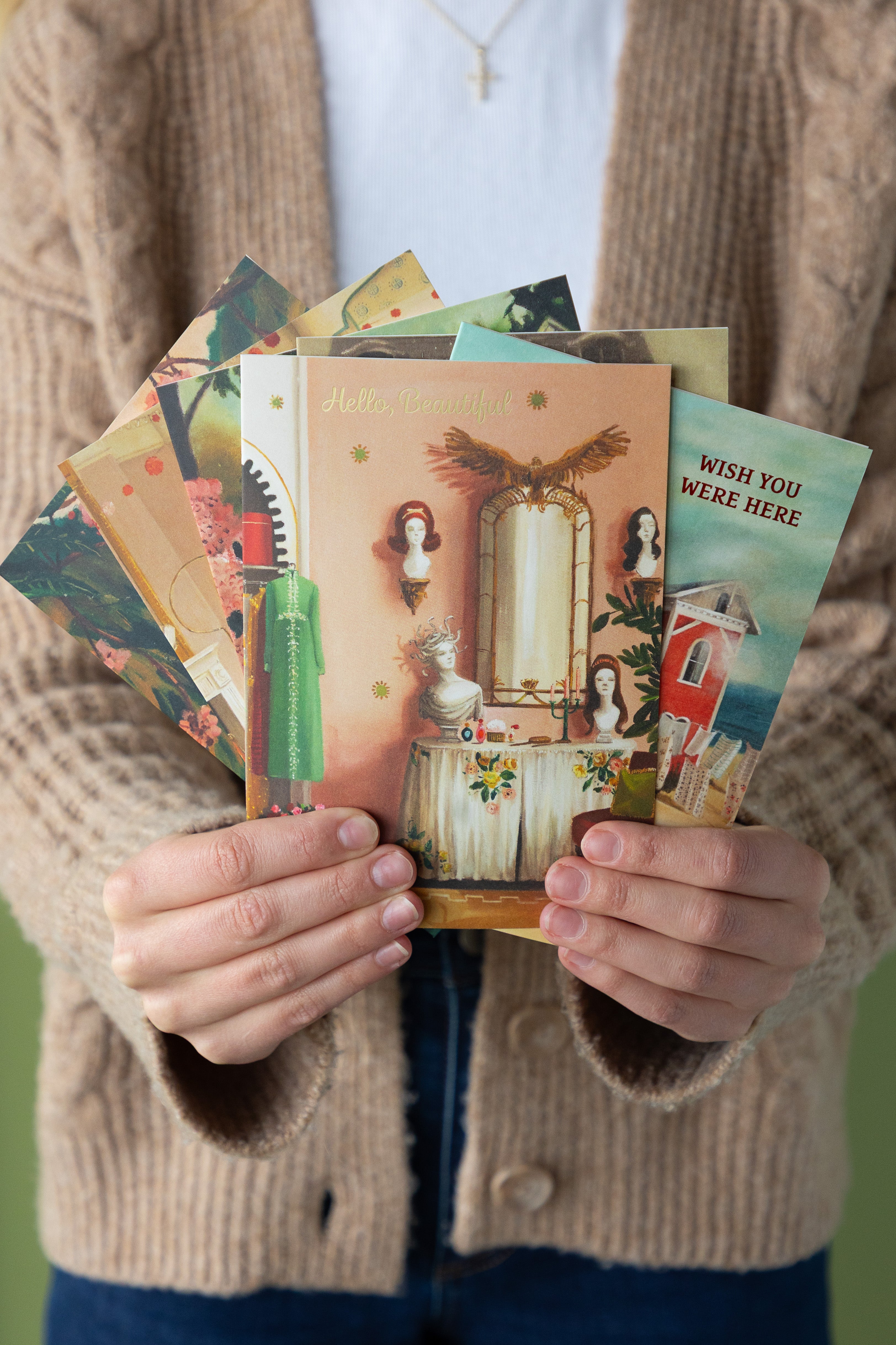Person holding a collection of vintage-style greeting cards.