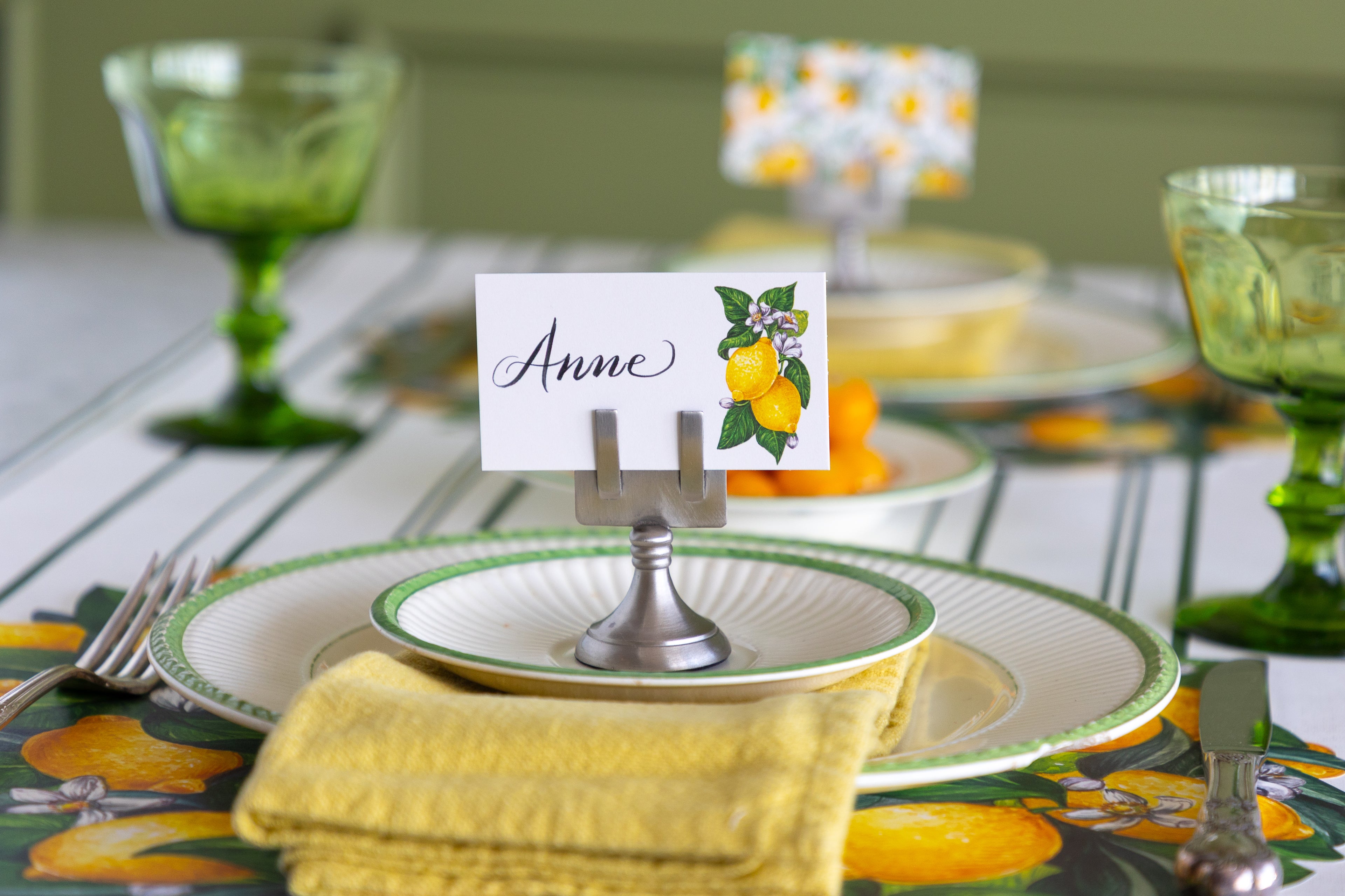A styled table setting with a white place card holder displaying a name card that reads &