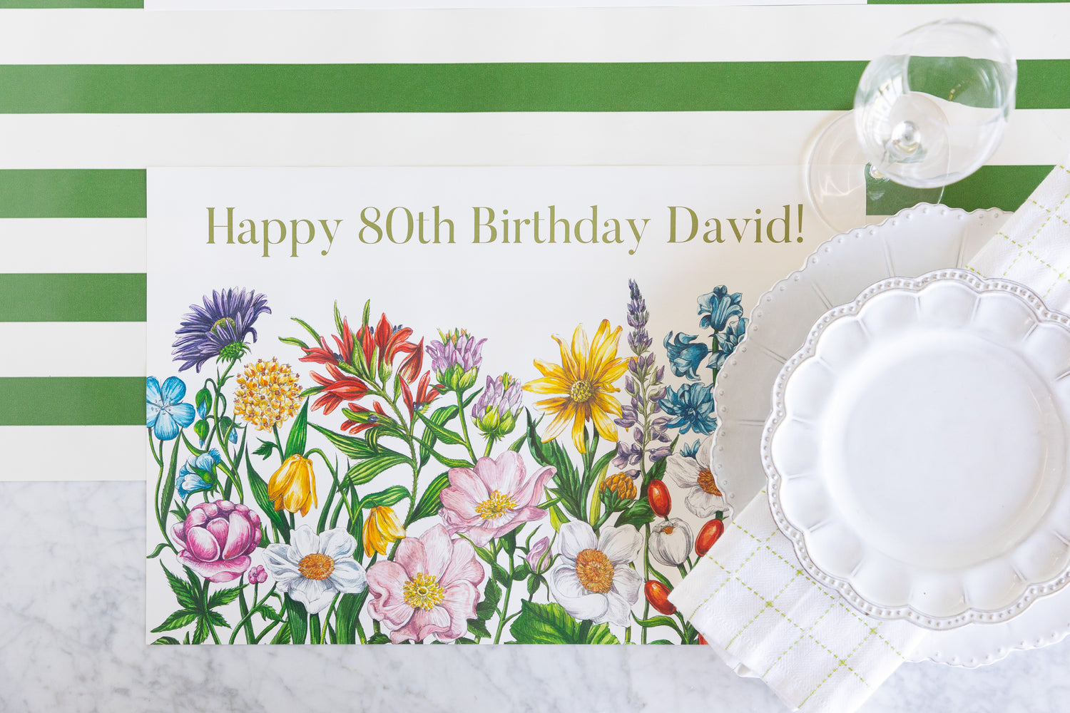 A rectangular birthday placemat with a colorful wildflower illustration and the text &