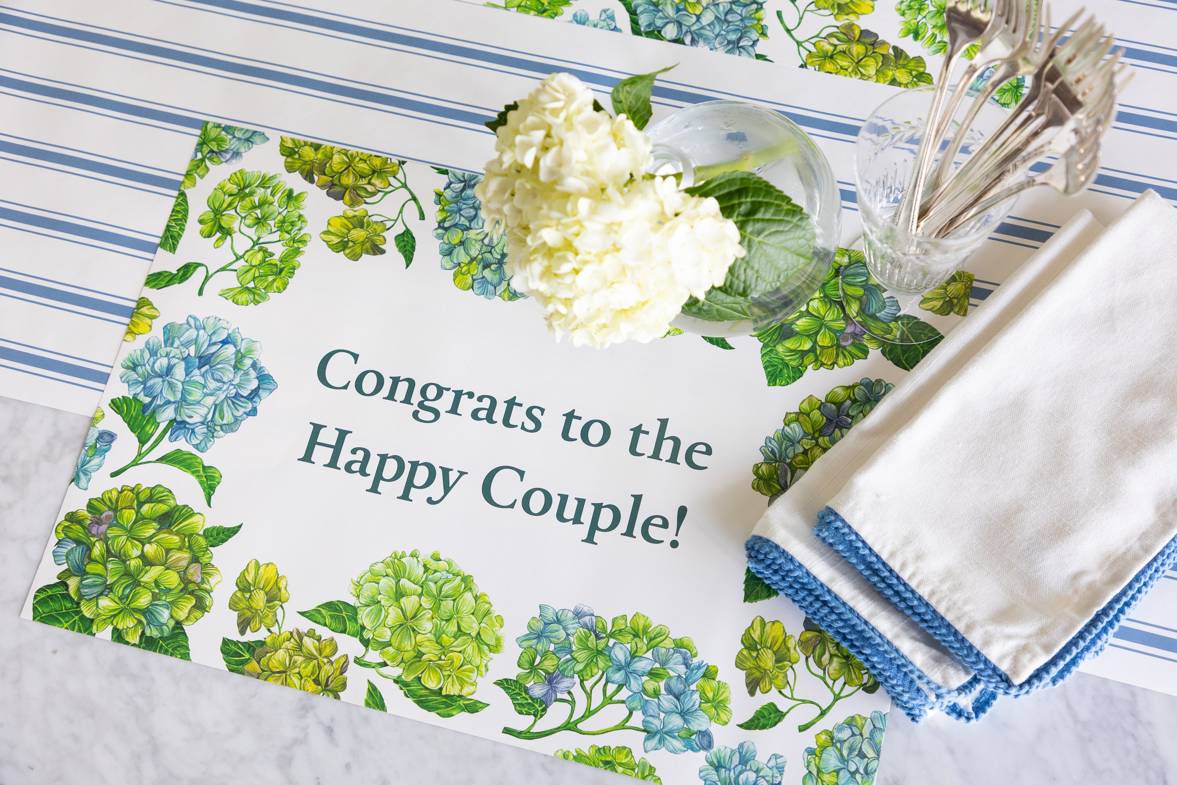 A rectangular printed placemat with a floral border and the text &