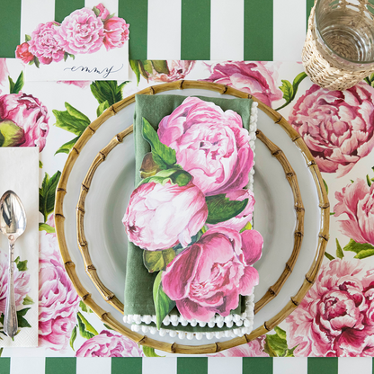 An elegant tablescape adorned with Peonies In Bloom Placemats by Hester &amp; Cook, enhanced by paper placemats.