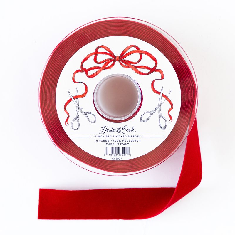 A spool of one-inch wide red flocked ribbon by Hester &amp; Cook on a white background. 