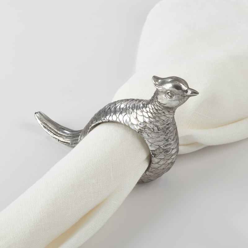 Silver pheasant shaped napkin ring holding a white napkin. 