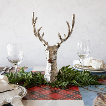 An aluminum Reindeer Bust, in the center of a woodland themed table setting, surrounded by a leaf garland.