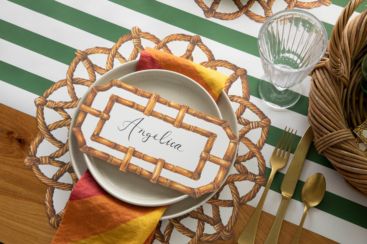 A place setting with a Die-cut Rattan Weave Placemat from Hester &amp; Cook, a plate, and a glass, accompanied by a napkin.