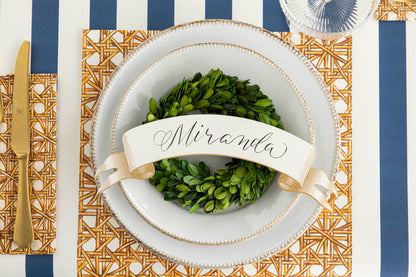 A classic Hester &amp; Cook Rattan Weave Placemat, adorned with a wreath.