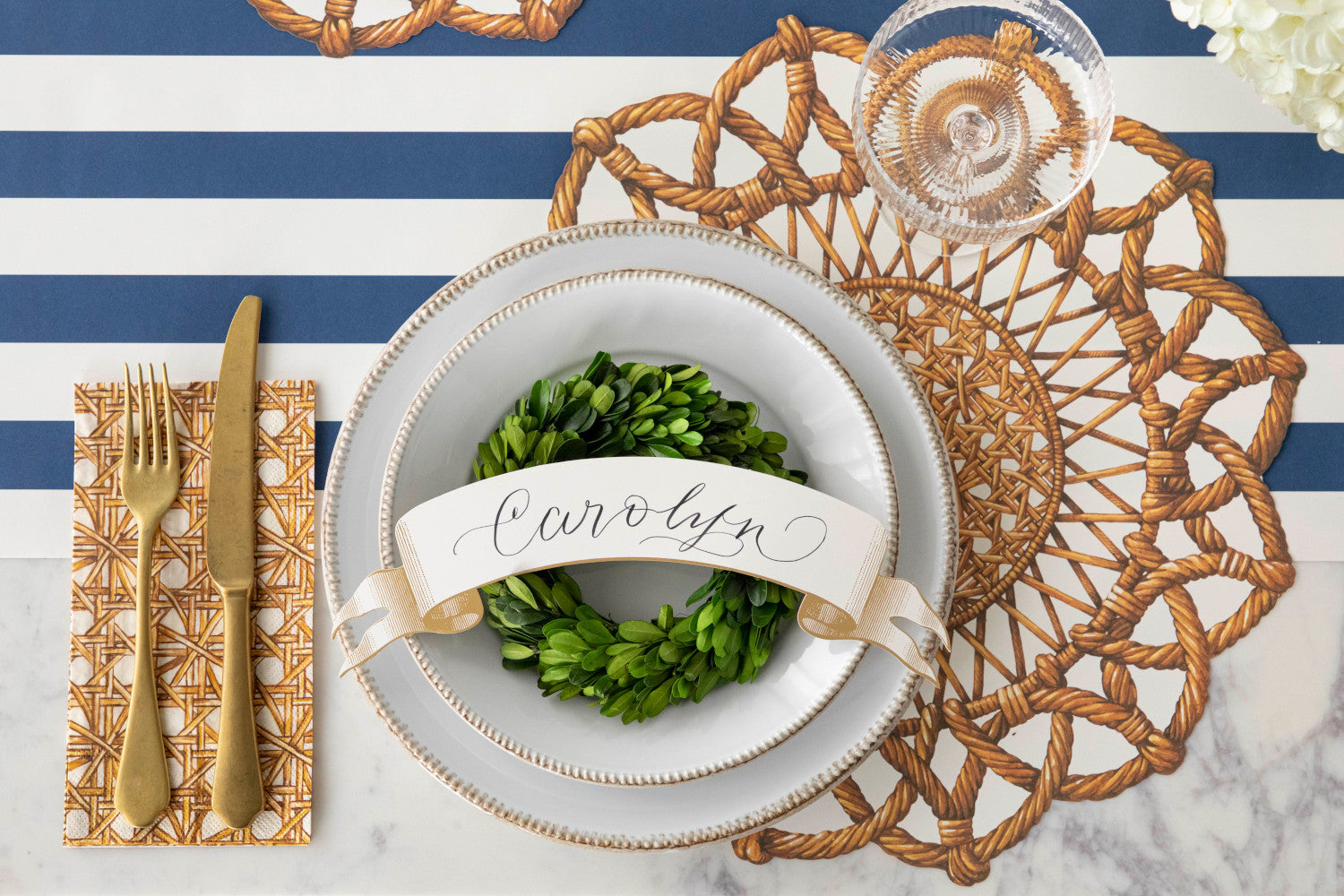 A vintage blue and white Rattan Weave Napkins place setting with a wreath on it, by Hester &amp; Cook.