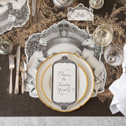 Regal Frame Table Card with &quot;Cheers to Twenty Years!&quot; written on it, resting on dinner plates on a regal table setting for one.