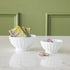 Two white BIA porcelain fluted bowls on a marble surface, one containing sprinkled chocolate bars and the other with chocolate pieces covered in sprinkles.