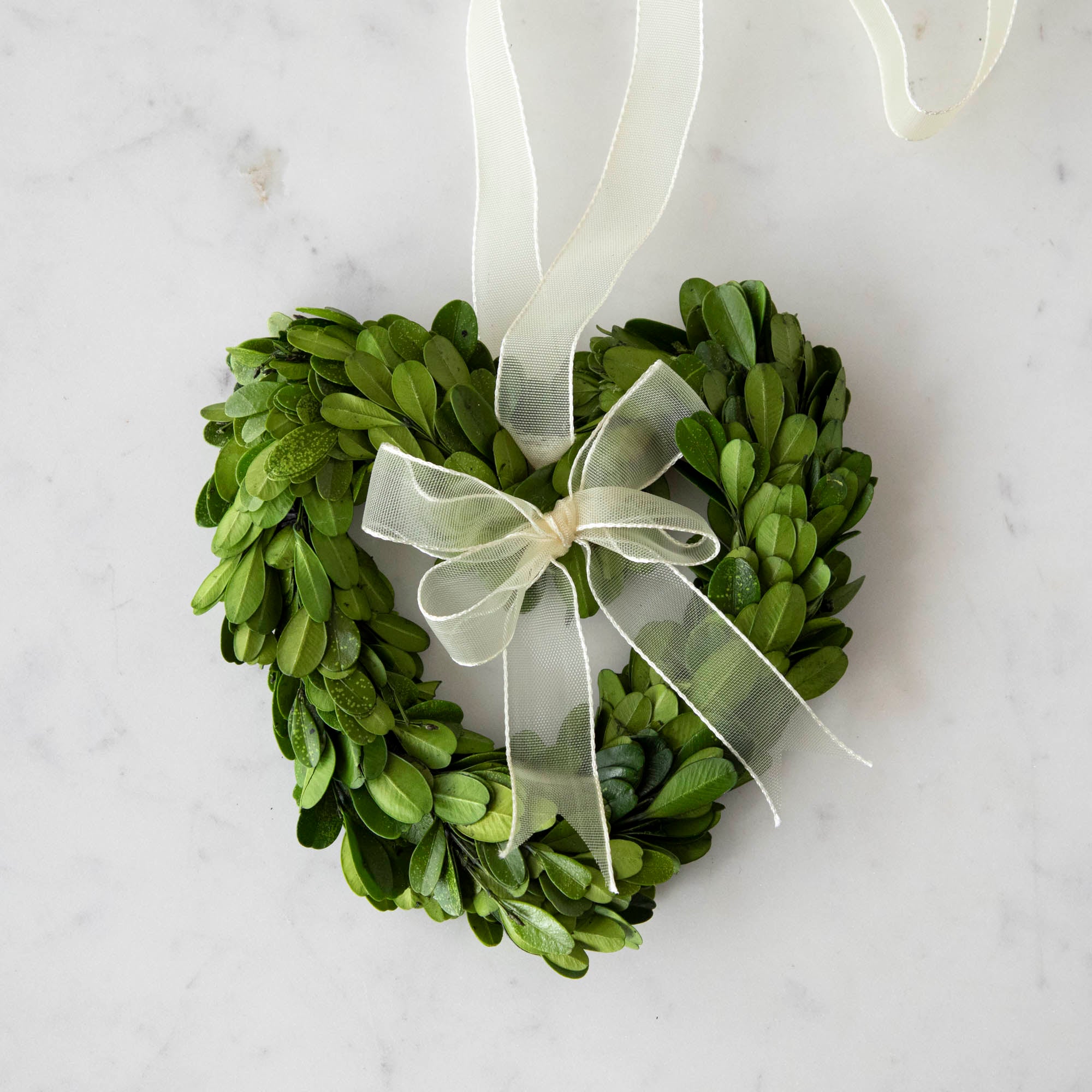 Three heart-shaped preserved Boxwood Wreath Hearts with Ribbons by Mills Floral Company on a white background.