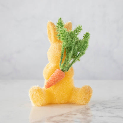 A yellow Easter decoration Flocked Bunny with Carrot from Glitterville, perfect for the spring season.