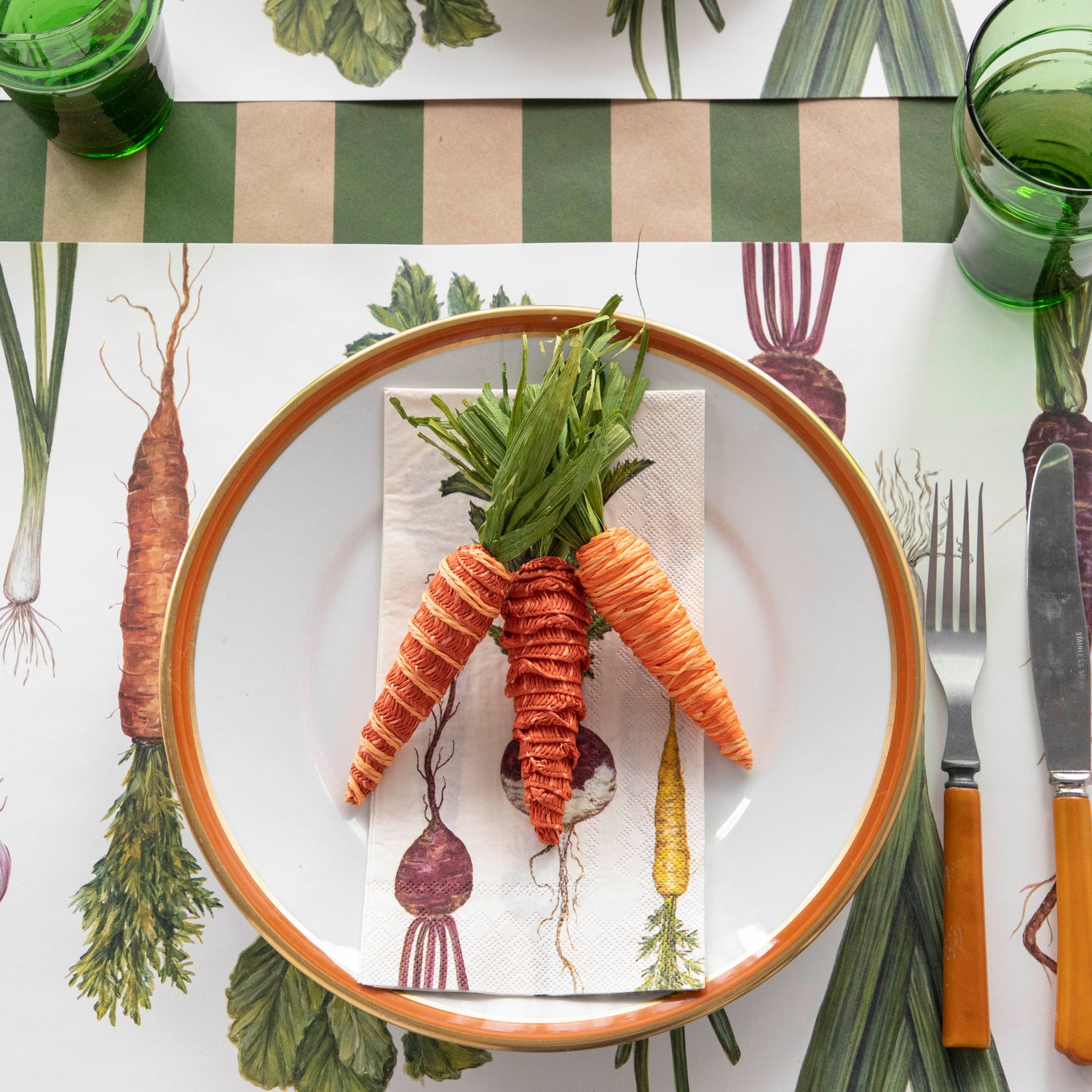 A plate with Glitterville Natural Carrots on it and a fork on it, all placed on a table setting.