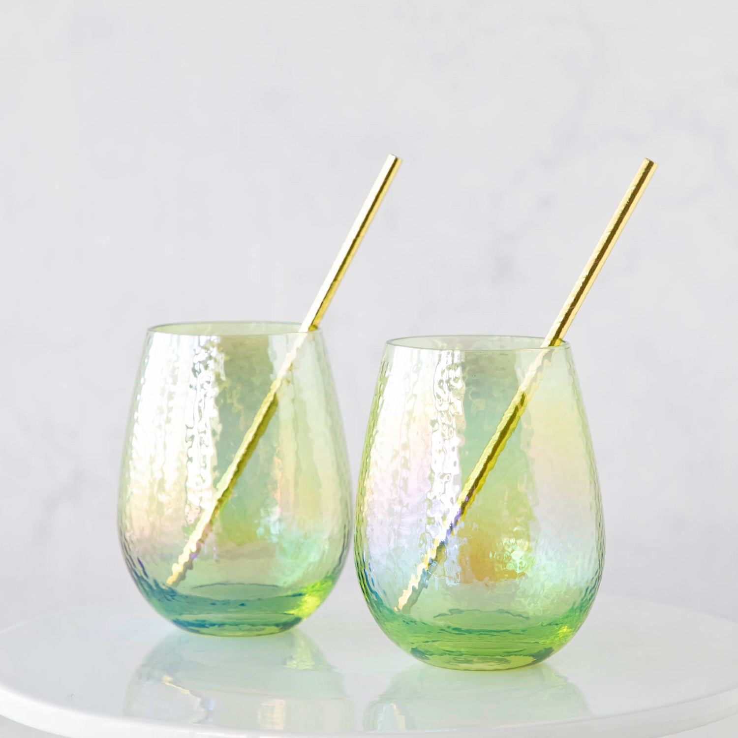 Two Luster Stemless Glassware with gold straws on a white plate. (Brand: Zodax)