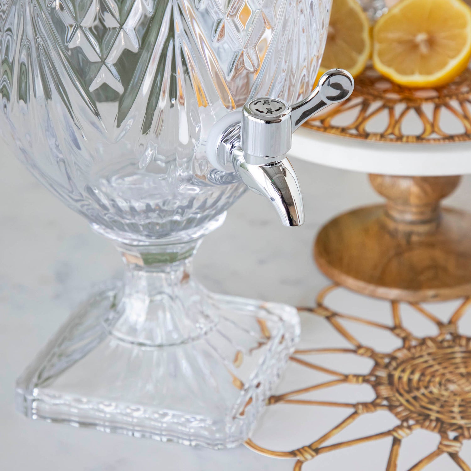 A close up of the Dublin Glass Beverage Dispenser showing its dispenser and square base.