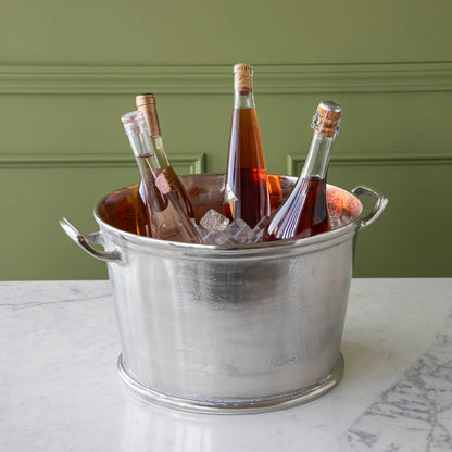 A Raw Aluminum Handled Planter/Wine Cooler filled with ice and wine bottles.