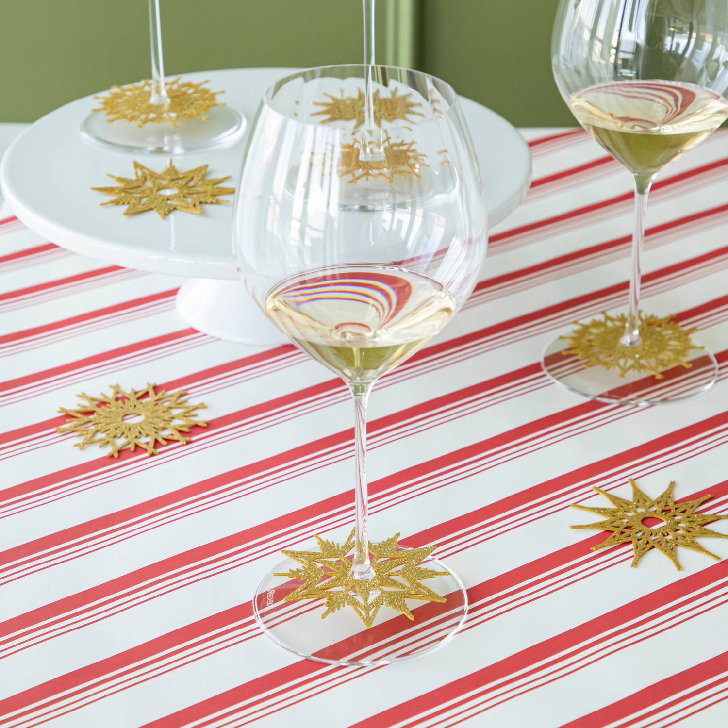 Stemware Snowflake collars on the bases of wine glasses and scattered on a Peppermint Stripe Runner.