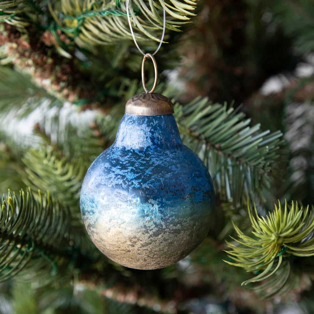 Blue Kugel Ornament hanging in a tree