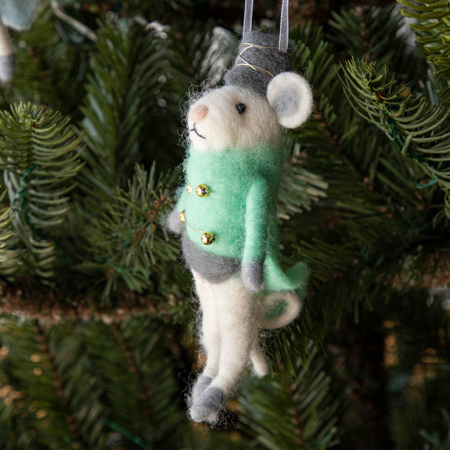 Felt Mouse Ornament with green band jacket on and a grey hat handing in a Christmas Tree