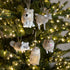Decorative animal ornaments on a Christmas tree with lights.