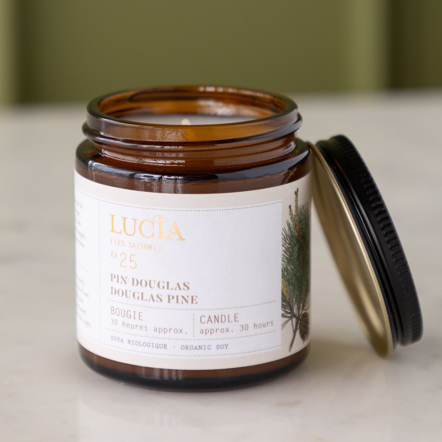 Lucia candle jar with label and lid on a neutral background