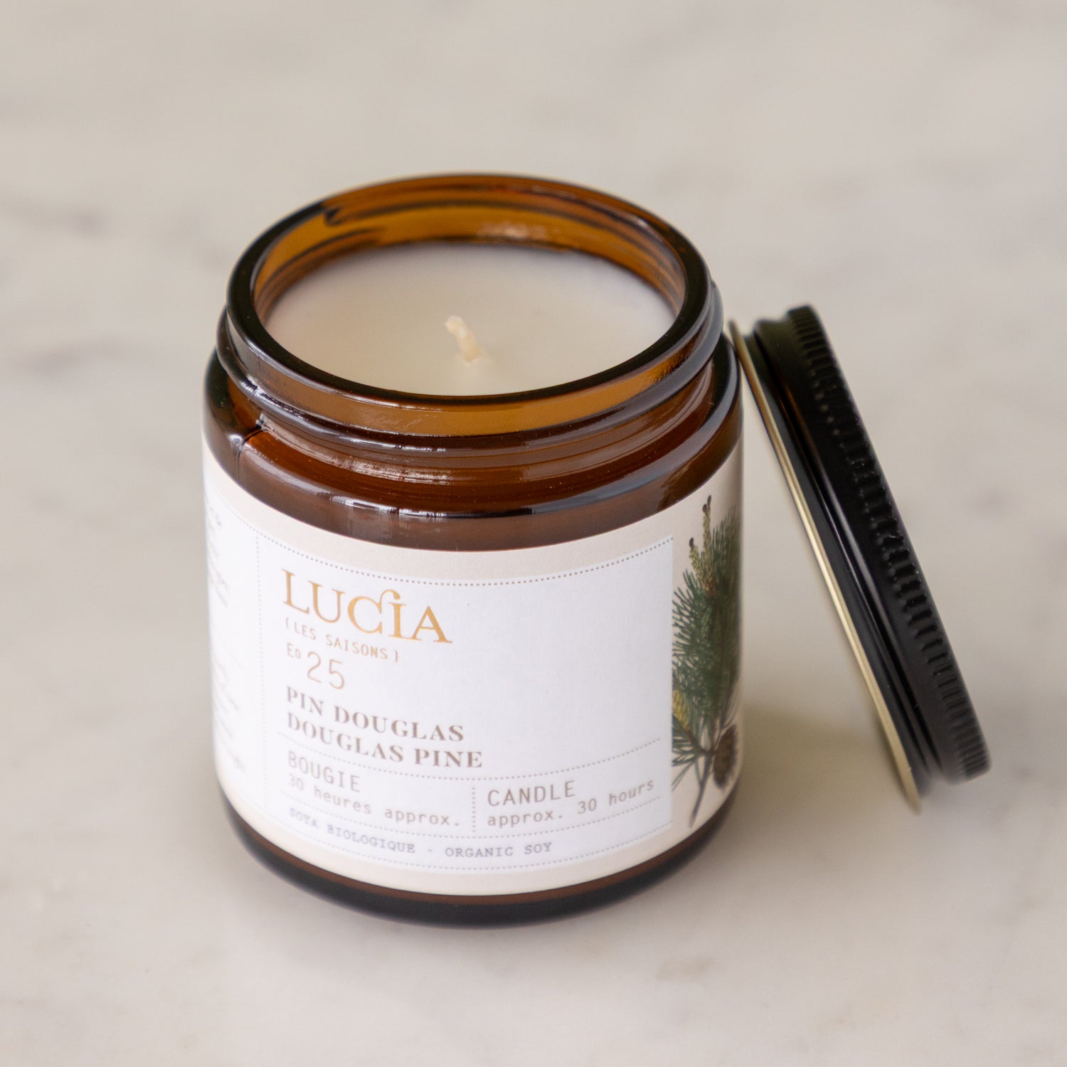 Lucia candle in a glass jar with a label on a neutral background