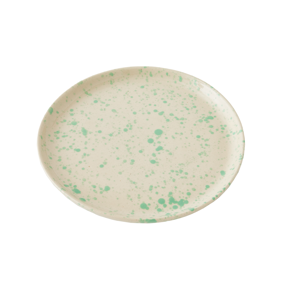 Round ceramic plate with green speckles on a white background