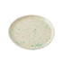 Round ceramic plate with green speckles on a white background