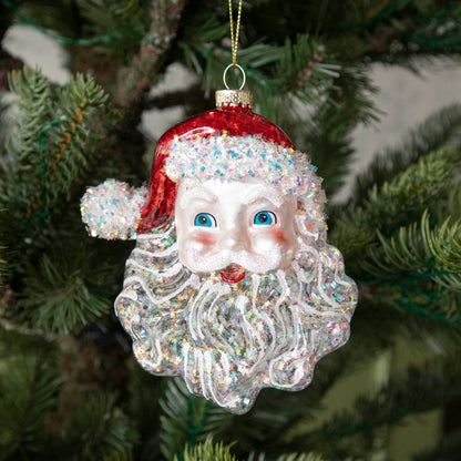 Glass Glitter Santa Head Ornament with a jolly face, hanging on a tree.