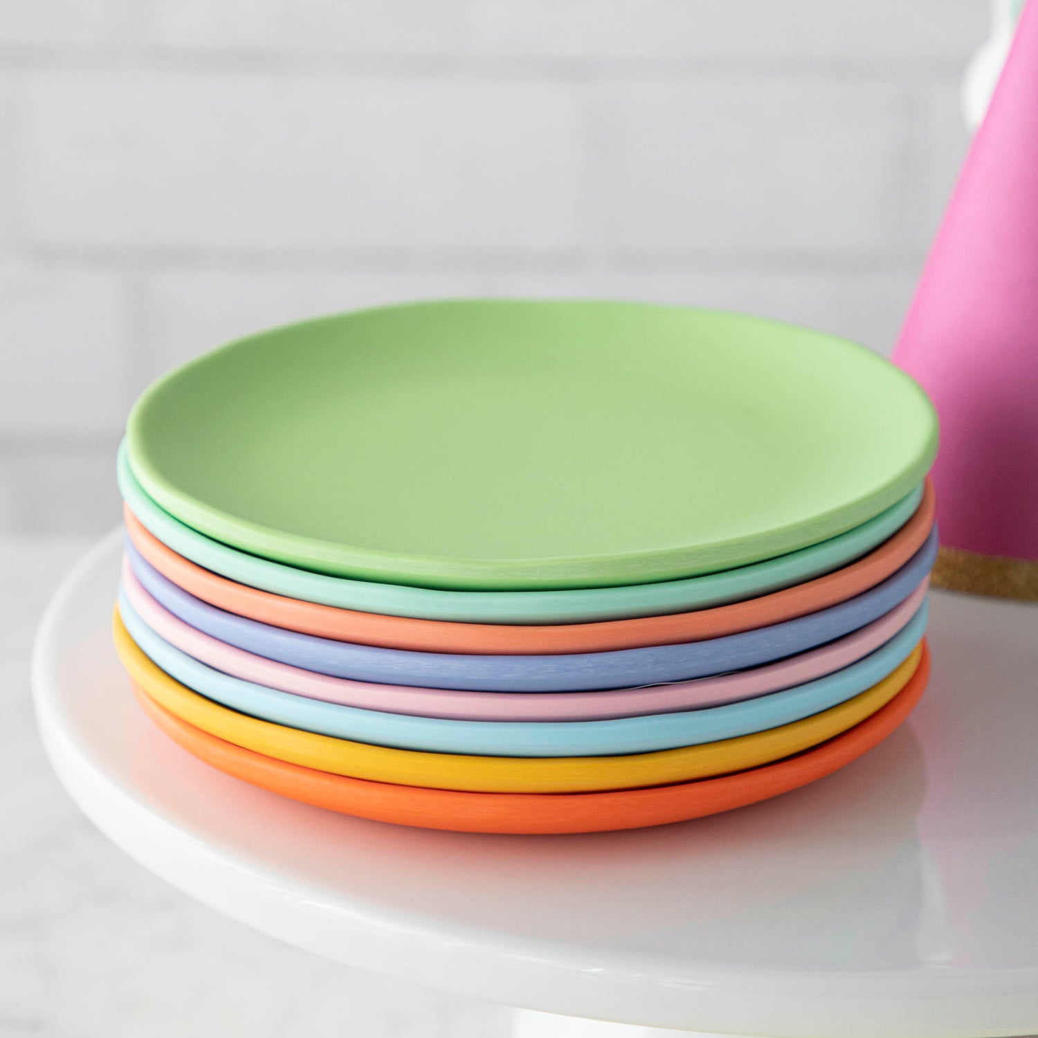 A stack of colorful plates on a cake plate.