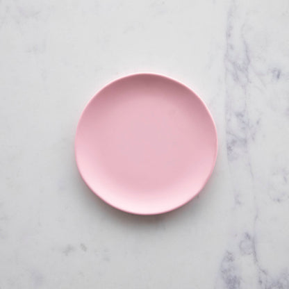 A 6&quot; cotton candy Rainbow Melamine Plate by Glitterville on a marble surface.