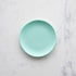 A 6" mint Rainbow Melamine Plate by Glitterville on a marble surface.