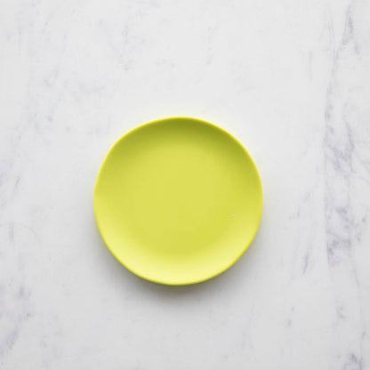 A colorful Glitterville Rainbow Melamine Plate on a marble surface.
