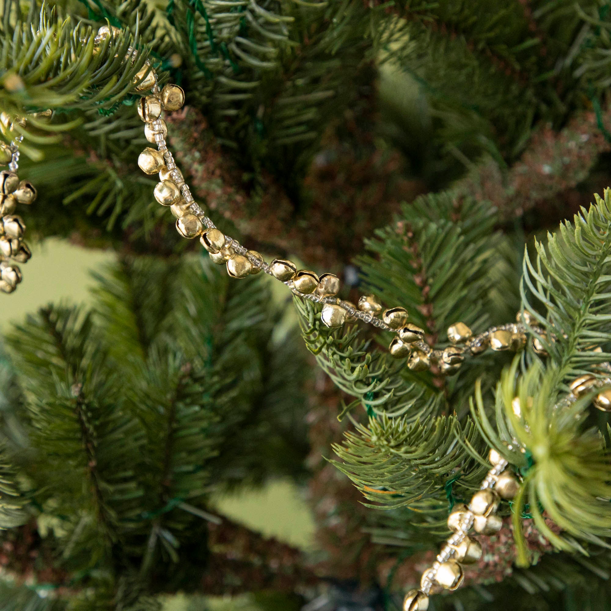 Festive bell garland draped on a tree.