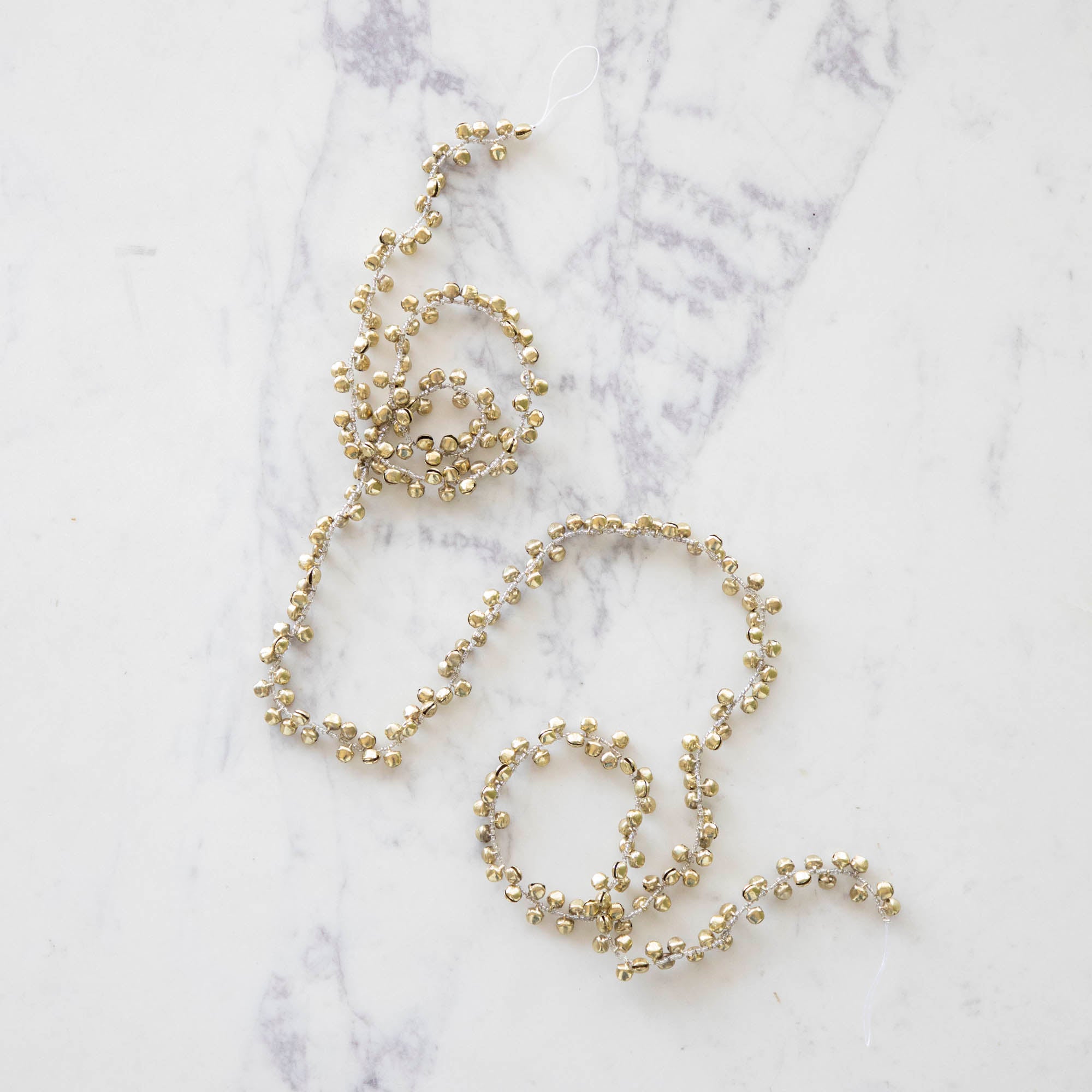 Festive bell garland on a marble table.