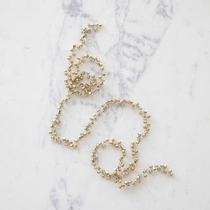 Festive bell garland on a marble table.