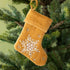 Mustard Velvet Stocking ornament hanging in a tree