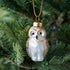 Glass owl ornament hanging in a tree