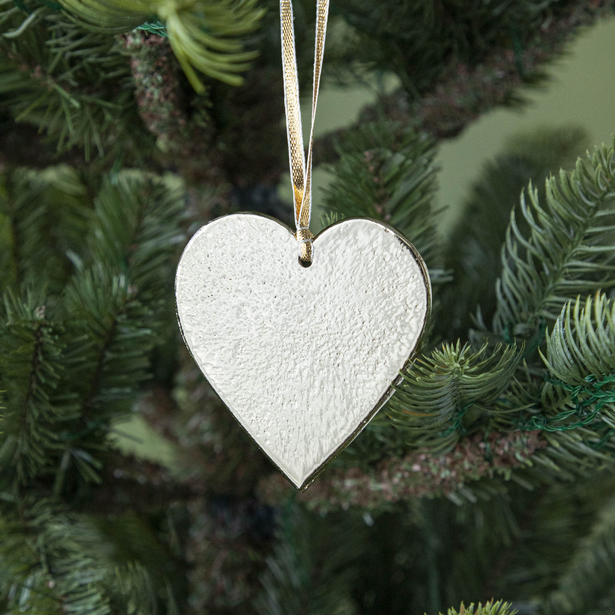 Gold metal heart ornament hanging in a tree