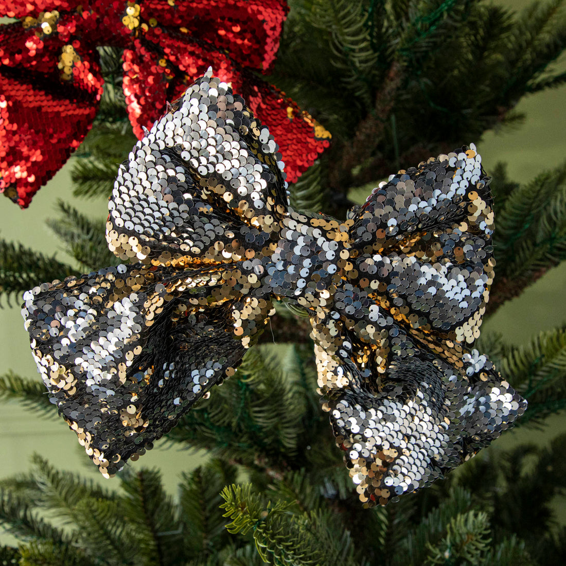 A close up of the gold Puffy Sequin Bow Ornament showing its reversible gold to silver sequins.