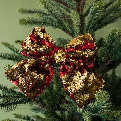 A close up of the red Puffy Sequin Bow Ornament showing its reversible red to gold sequins.