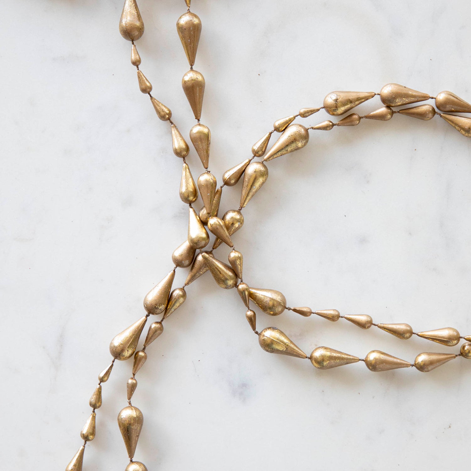 Close up of drop gold garland laying on a table.